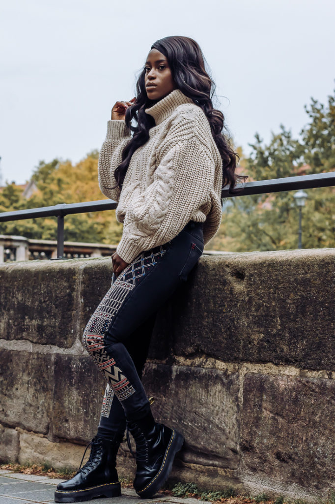 Ama Poku from the blog Phuck it Fashion wearing a chunky knit sweater and embroidered jeans