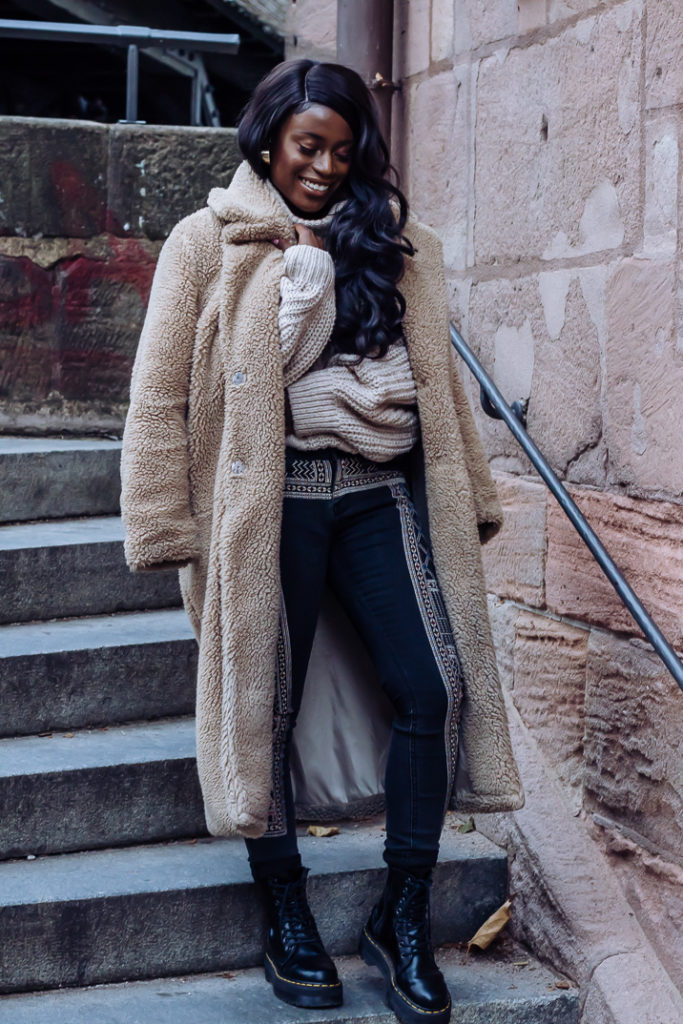 Ama Poku from the blog Phuck it Fashion wearing a chunky knit sweater and embroidered jeans