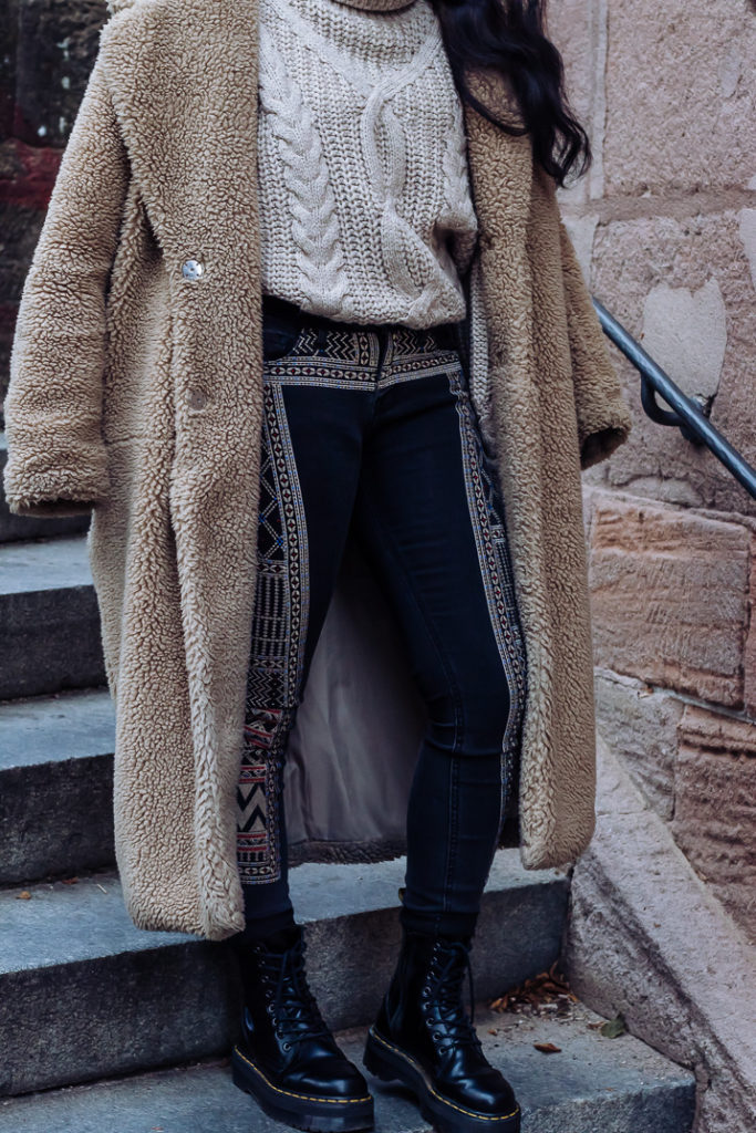 Ama Poku from the blog Phuck it Fashion wearing a chunky knit sweater and embroidered jeans